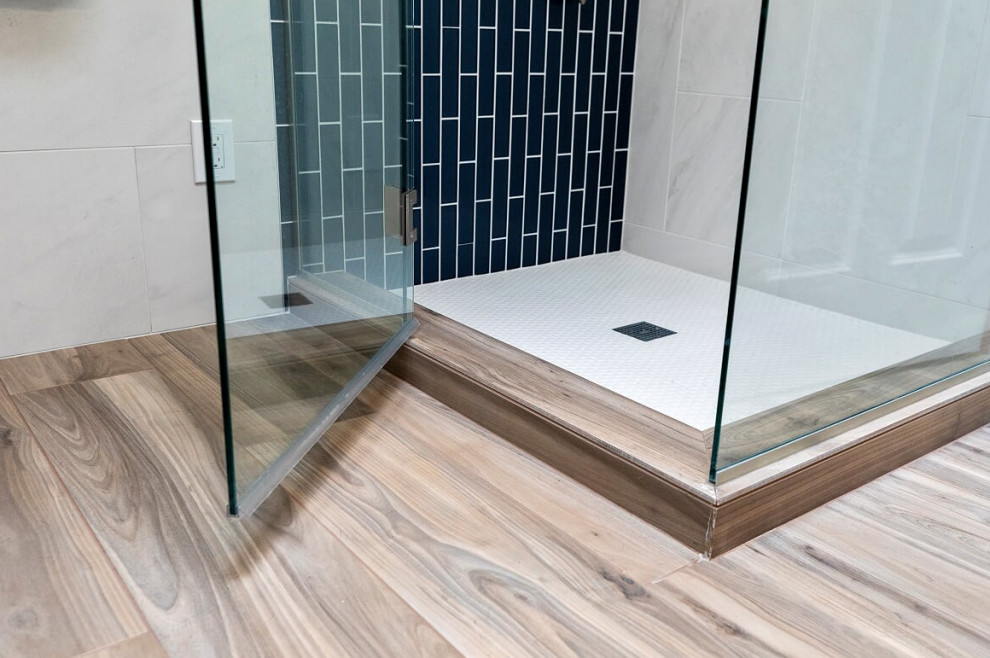 Design ideas for a medium sized classic ensuite wet room bathroom in Seattle with a claw-foot bath, a one-piece toilet, white tiles, porcelain tiles, white walls, porcelain flooring, a pedestal sink, brown floors, a hinged door, double sinks, a freestanding vanity unit and wainscoting.