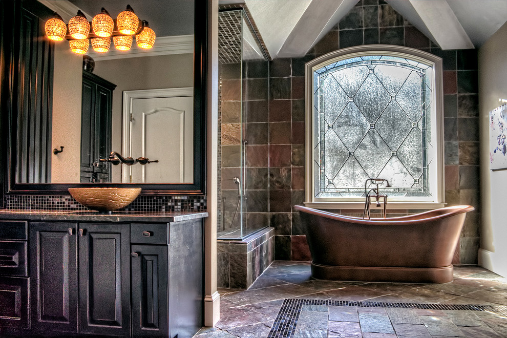 Large elegant master multicolored tile and stone tile slate floor freestanding bathtub photo in Atlanta with a vessel sink, raised-panel cabinets, black cabinets, granite countertops and brown walls