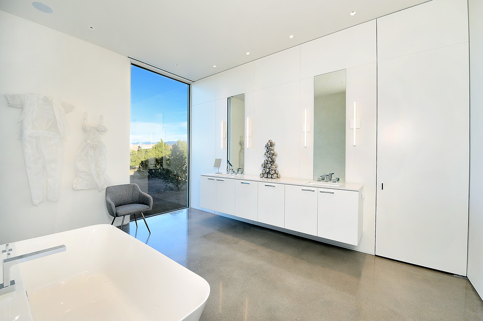 Modernes Badezimmer En Suite mit flächenbündigen Schrankfronten, weißen Schränken, weißer Wandfarbe, Betonboden, Unterbauwaschbecken und grauem Boden in Sonstige