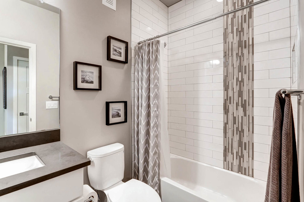 Пример оригинального дизайна: ванная комната среднего размера в современном стиле с фасадами в стиле шейкер, белыми фасадами, ванной в нише, душем над ванной, раздельным унитазом, бежевой плиткой, черной плиткой, удлиненной плиткой, бежевыми стенами, полом из ламината, душевой кабиной, врезной раковиной, столешницей из бетона, серым полом, шторкой для ванной и серой столешницей