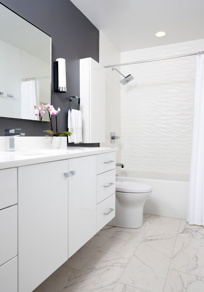 Exempel på ett mellanstort modernt badrum, med släta luckor, vita skåp, vita väggar, bänkskiva i kvarts, ett badkar i en alkov, en dusch/badkar-kombination, en toalettstol med hel cisternkåpa, klinkergolv i porslin, ett undermonterad handfat och flerfärgad kakel