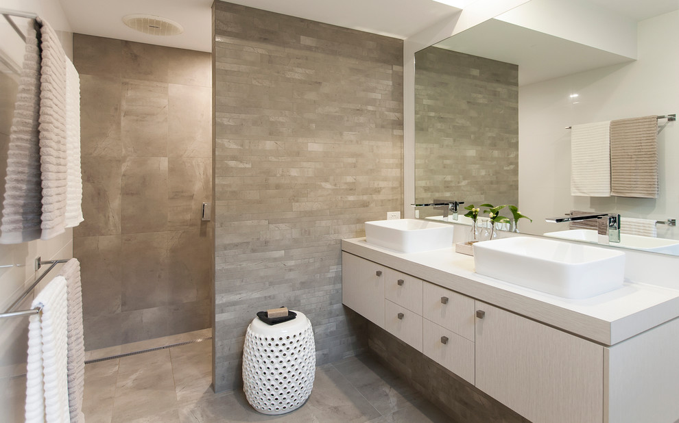 Exempel på ett mellanstort modernt badrum för barn, med ett fristående handfat, släta luckor, grå skåp, laminatbänkskiva, en dusch i en alkov, grå kakel, porslinskakel, vita väggar och klinkergolv i porslin