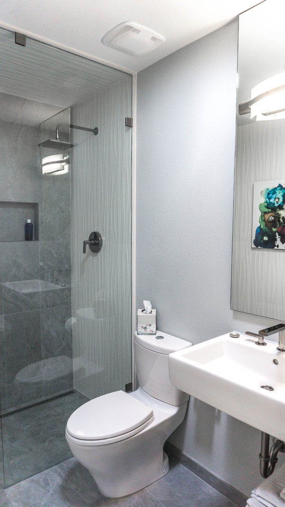 Пример оригинального дизайна: маленькая ванная комната в современном стиле с открытым душем, раздельным унитазом, серой плиткой, плиткой из травертина, серыми стенами, полом из травертина, подвесной раковиной и серым полом для на участке и в саду
