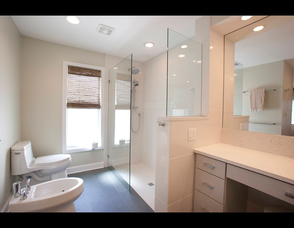 Cette photo montre une salle de bain principale tendance de taille moyenne avec un placard à porte plane, des portes de placard grises, une douche d'angle, un bidet, un carrelage blanc et un sol en ardoise.