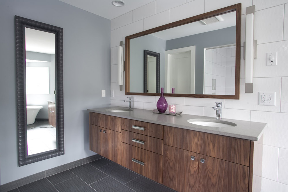 Ejemplo de cuarto de baño actual con armarios con paneles lisos, puertas de armario de madera en tonos medios y baldosas y/o azulejos blancos