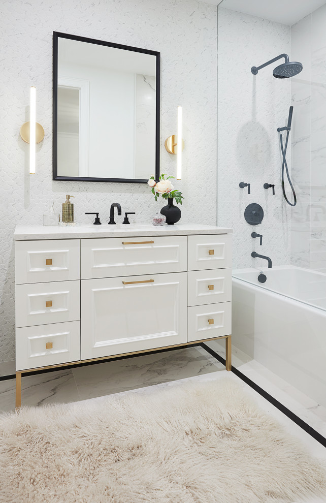 Medium sized family bathroom in Toronto with flat-panel cabinets, white cabinets, a built-in bath, a shower/bath combination, white tiles, white walls, marble flooring, a submerged sink, engineered stone worktops, white floors, a hinged door, white worktops, a single sink and a freestanding vanity unit.