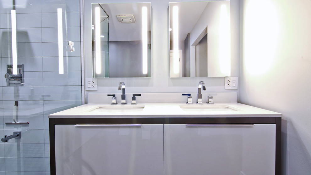 На фото: маленькая главная ванная комната в стиле модернизм с плоскими фасадами, белыми фасадами, белой плиткой, серыми стенами, врезной раковиной и столешницей из кварцита для на участке и в саду