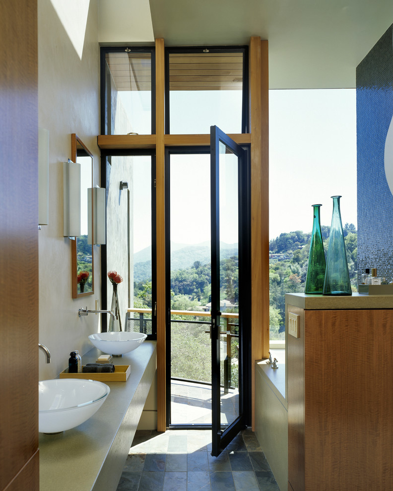 Cette image montre une salle de bain minimaliste avec un plan de toilette en béton et une vasque.