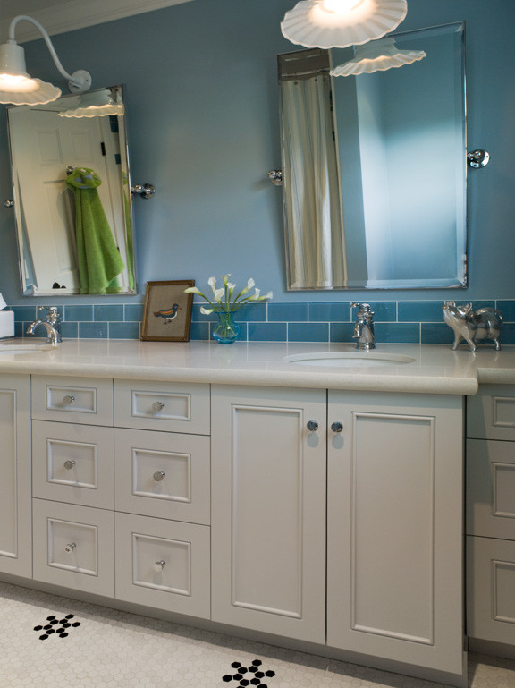Exemple d'une salle de bain chic de taille moyenne pour enfant avec un placard avec porte à panneau encastré, des portes de placard blanches, un carrelage bleu, un carrelage en pâte de verre, un mur bleu, un sol en carrelage de terre cuite, un lavabo encastré, un plan de toilette en surface solide et un sol blanc.