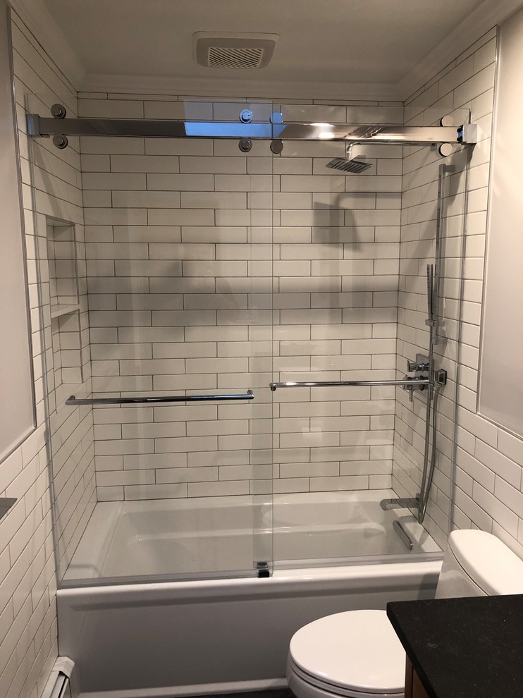 This is an example of a bathroom in New York with a built-in bath, a shower/bath combination and a sliding door.