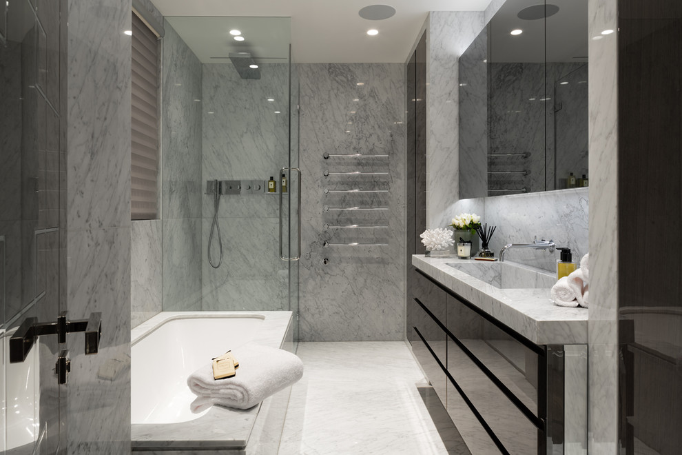 Idée de décoration pour une salle de bain principale design avec un placard à porte plane, des portes de placard noires, une baignoire encastrée, une douche d'angle, un mur gris, un lavabo intégré, un plan de toilette en marbre, un sol gris et une cabine de douche à porte battante.