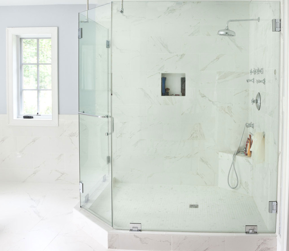 Klassisk inredning av ett stort en-suite badrum, med ett piedestal handfat, ett fristående badkar, en hörndusch, vit kakel, porslinskakel, blå väggar och klinkergolv i porslin