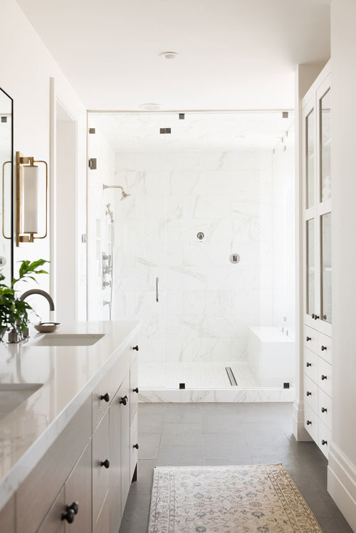 Пример оригинального дизайна: большая главная ванная комната в стиле неоклассика (современная классика) с светлыми деревянными фасадами, отдельно стоящей ванной, угловым душем, белыми стенами, полом из керамической плитки, мраморной столешницей, серым полом, душем с распашными дверями и разноцветной столешницей