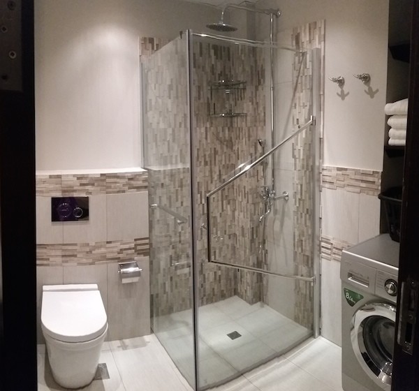 Cette photo montre une salle de bain principale tendance de taille moyenne avec un lavabo posé, un placard à porte plane, un carrelage de pierre, un mur gris et un sol en carrelage de céramique.