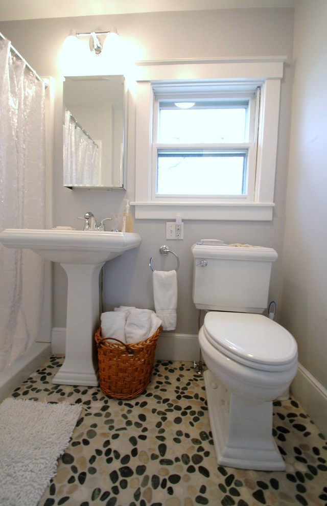 Klassisk inredning av ett badrum, med ett piedestal handfat och en toalettstol med separat cisternkåpa