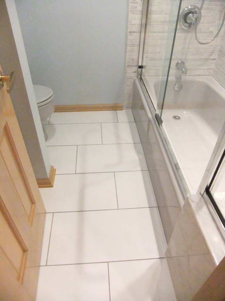 Foto på ett litet vintage badrum, med ett badkar i en alkov, en dusch/badkar-kombination, en toalettstol med separat cisternkåpa, grå kakel, mosaik, blå väggar och klinkergolv i porslin
