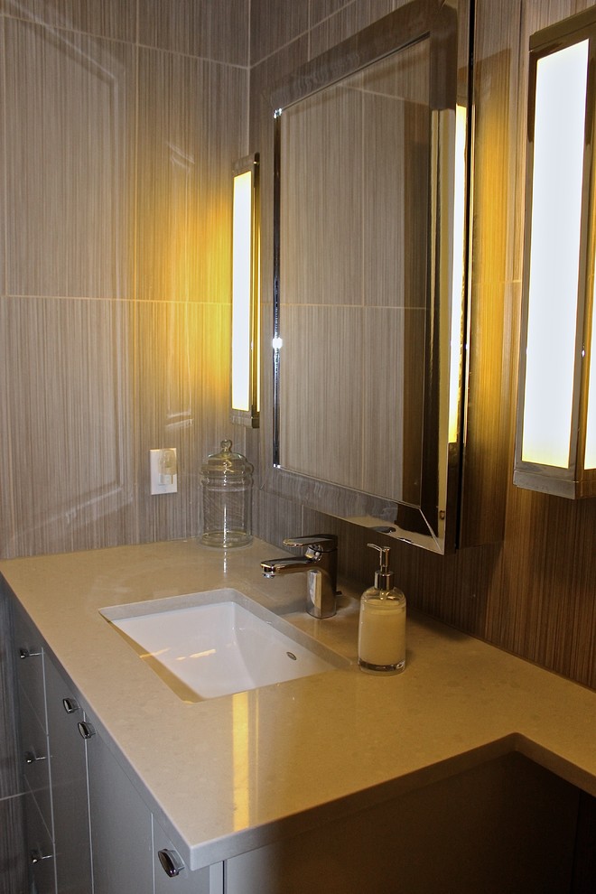 Пример оригинального дизайна: маленькая ванная комната в современном стиле с врезной раковиной, плоскими фасадами, белыми фасадами, столешницей из кварцита, ванной в нише, душем над ванной, унитазом-моноблоком, серой плиткой, керамогранитной плиткой, серыми стенами и полом из керамогранита для на участке и в саду