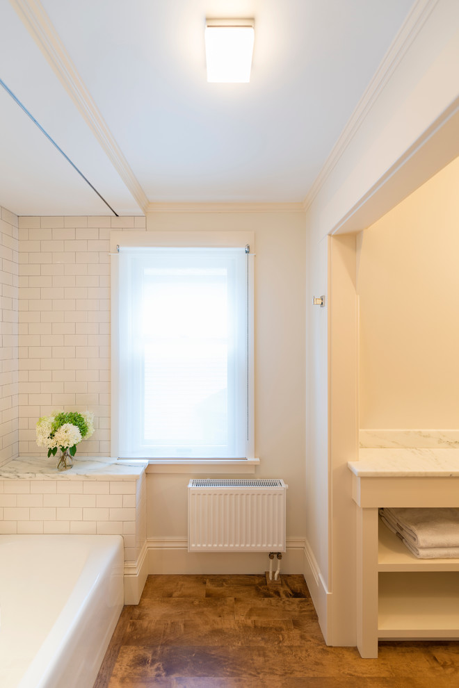 На фото: маленькая ванная комната в классическом стиле с белыми фасадами, накладной ванной, душем над ванной, белой плиткой, плиткой кабанчик, белыми стенами и паркетным полом среднего тона для на участке и в саду