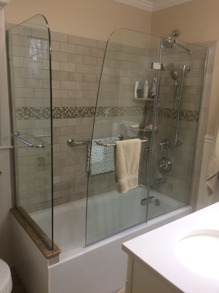 Exemple d'une petite salle d'eau craftsman avec des portes de placard blanches, une baignoire d'angle, un combiné douche/baignoire, WC séparés, un carrelage beige, un carrelage marron, un carrelage de pierre, un mur beige, un sol en carrelage de céramique, un lavabo suspendu, un plan de toilette en surface solide, un sol beige et une cabine de douche à porte battante.