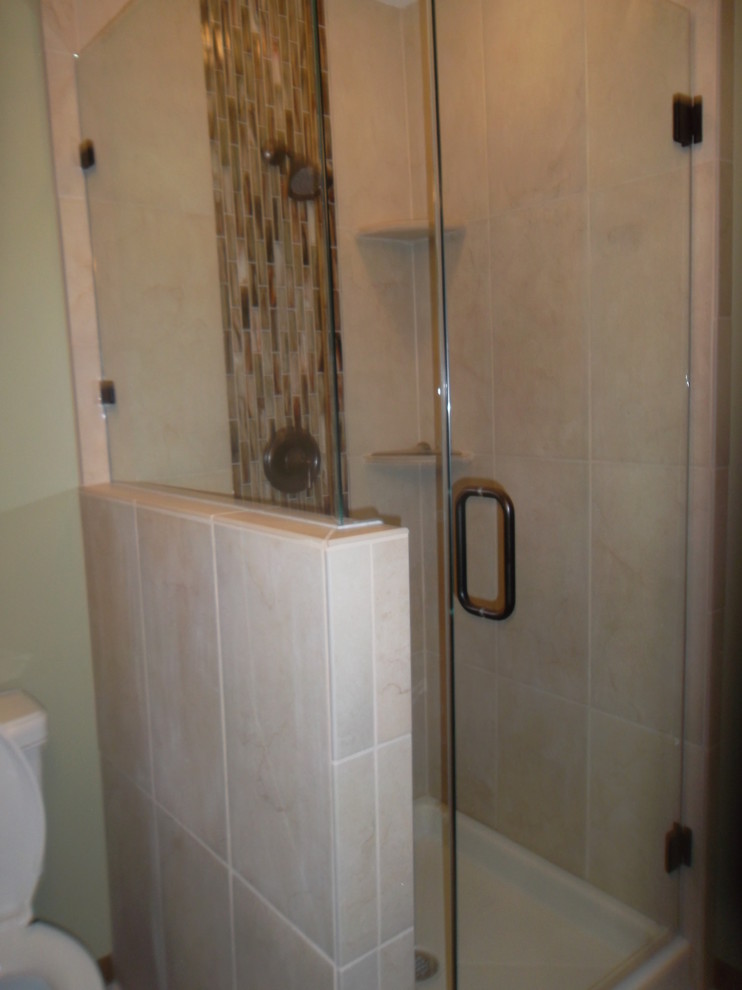 Small elegant 3/4 limestone floor corner shower photo in Milwaukee with an integrated sink, recessed-panel cabinets, dark wood cabinets, a two-piece toilet and green walls