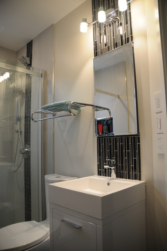 Diseño de cuarto de baño moderno pequeño con puertas de armario blancas, ducha empotrada, sanitario de dos piezas, baldosas y/o azulejos negros, baldosas y/o azulejos de porcelana y suelo de baldosas de porcelana