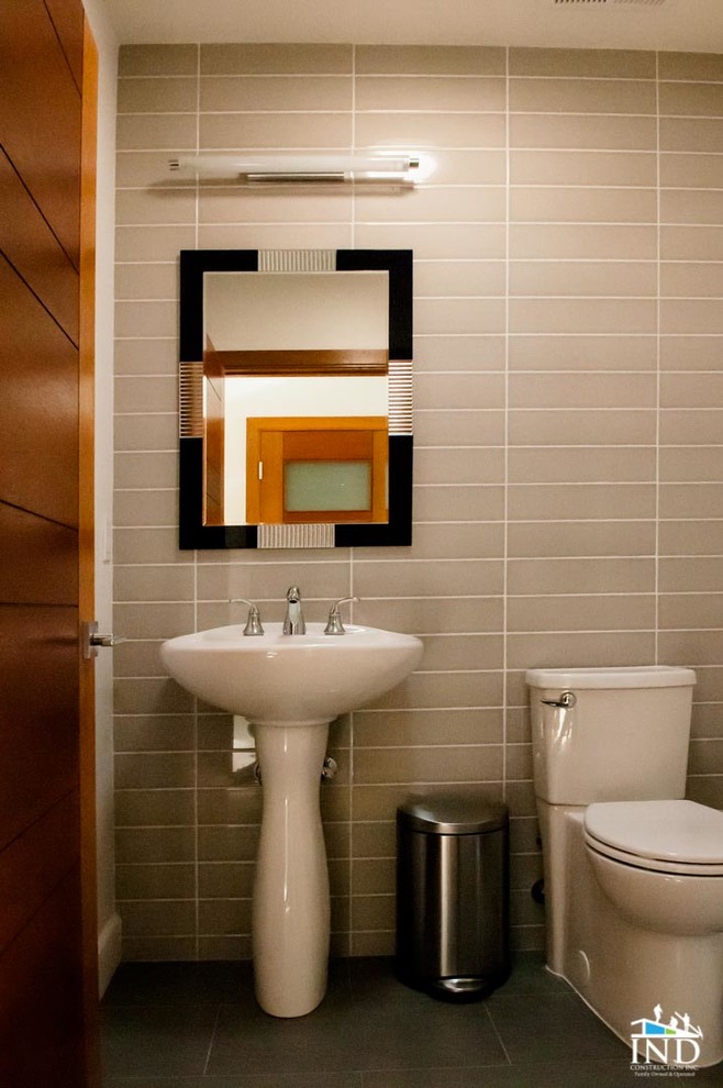 Inredning av ett modernt mellanstort badrum med dusch, med en toalettstol med separat cisternkåpa, grå kakel, porslinskakel, grå väggar, klinkergolv i porslin och ett piedestal handfat