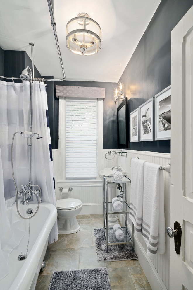 Foto på ett litet vintage badrum med dusch, med ett badkar med tassar, en dusch/badkar-kombination, en toalettstol med hel cisternkåpa, vit kakel, blå väggar, klinkergolv i keramik, ett avlångt handfat, beiget golv och dusch med duschdraperi
