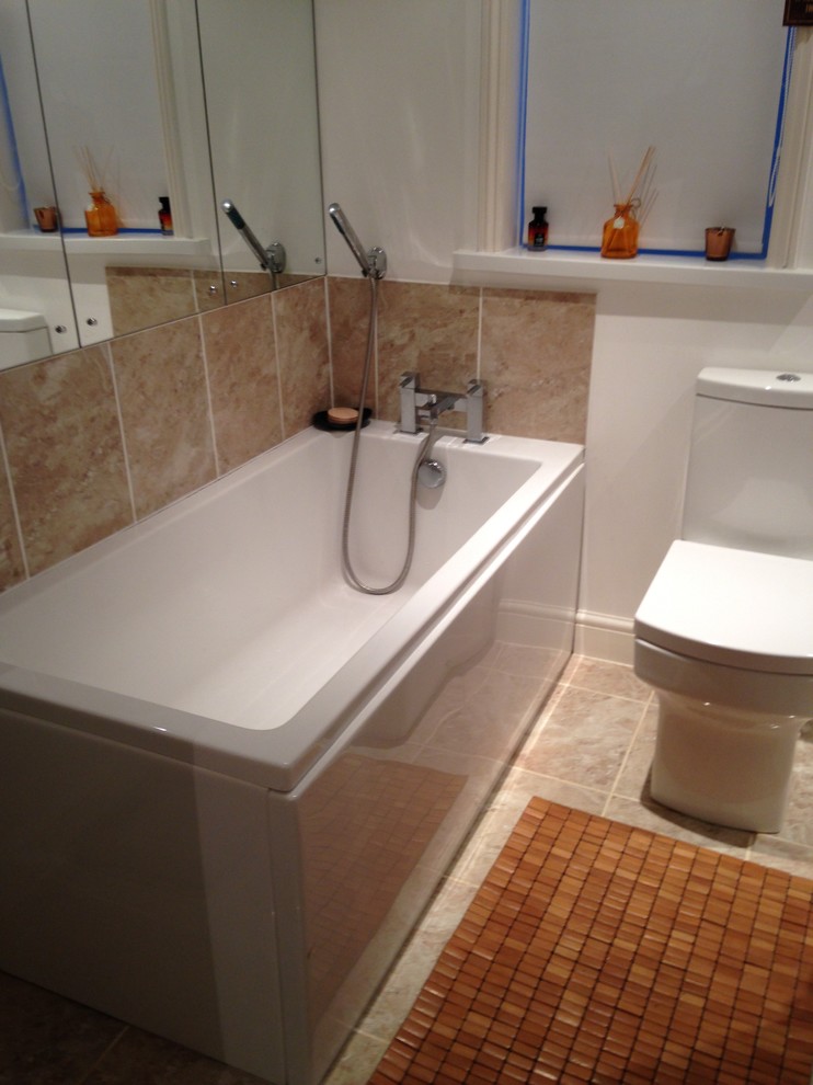 Small modern family bathroom in Devon with a built-in bath, a built-in shower, a two-piece toilet, beige tiles, white walls, marble flooring and a trough sink.