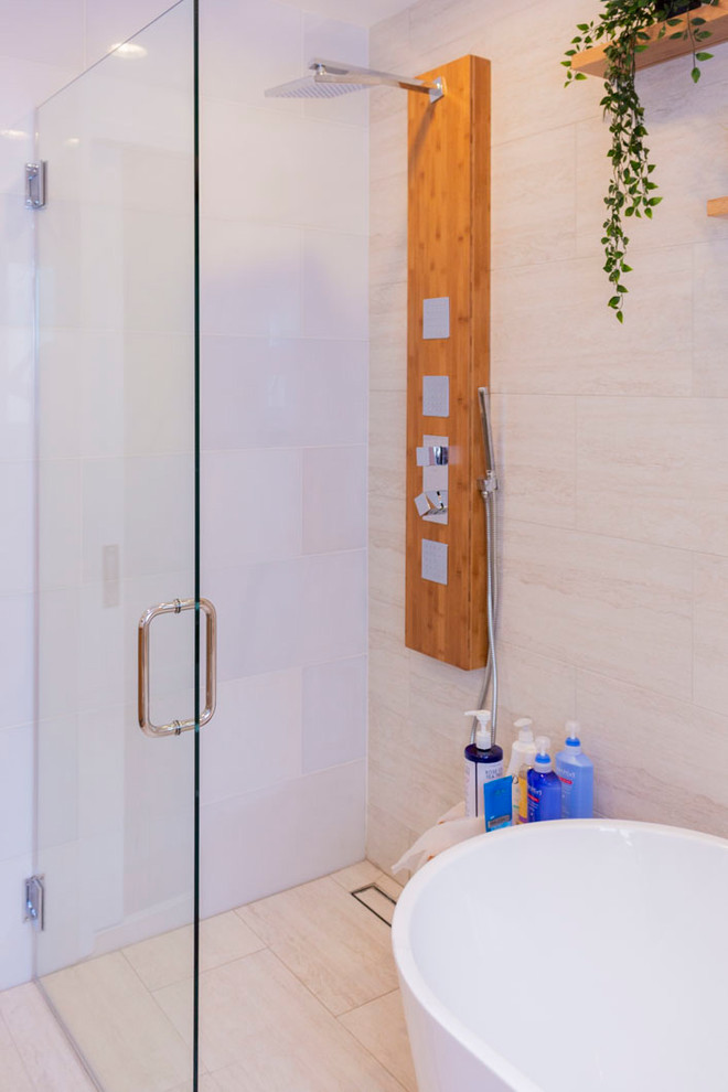 Photo of a medium sized contemporary ensuite bathroom in Los Angeles with freestanding cabinets, light wood cabinets, a freestanding bath, a corner shower, a one-piece toilet, beige tiles, porcelain tiles, beige walls, laminate floors, a submerged sink, wooden worktops, beige floors, an open shower and brown worktops.