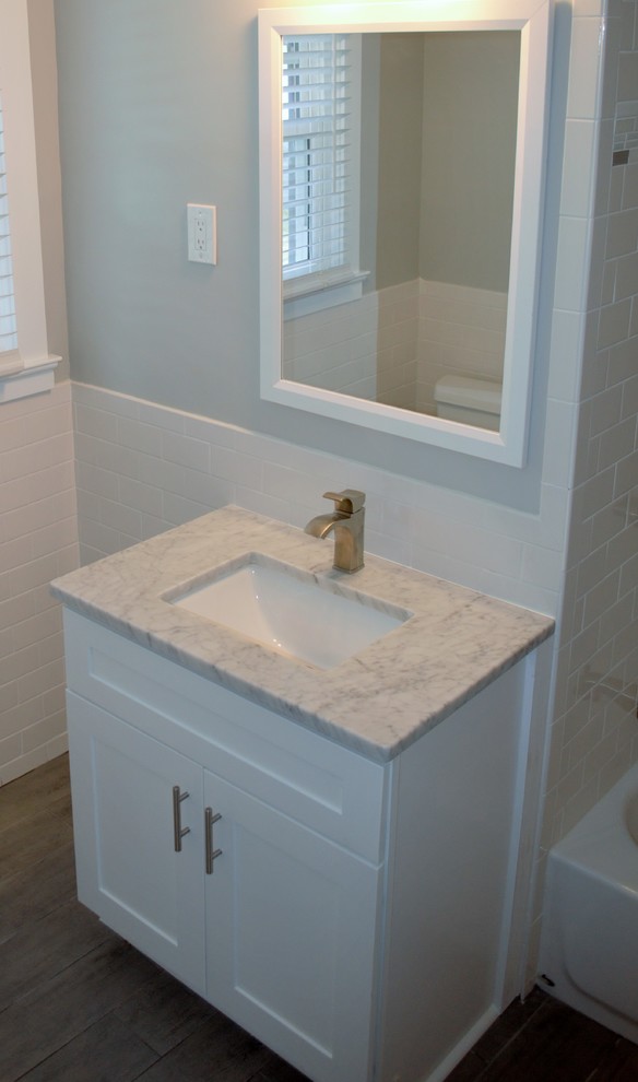 Foto på ett litet vintage badrum med dusch, med skåp i shakerstil, vita skåp, ett badkar med tassar, en dusch/badkar-kombination, vit kakel, keramikplattor, vita väggar, ett undermonterad handfat och granitbänkskiva