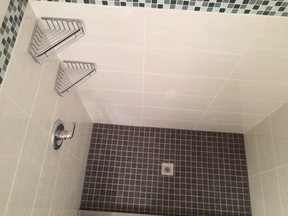 Foto på ett mellanstort funkis badrum med dusch, med släta luckor, vita skåp, en dusch i en alkov, vit kakel, porslinskakel, vita väggar, klinkergolv i keramik och ett integrerad handfat