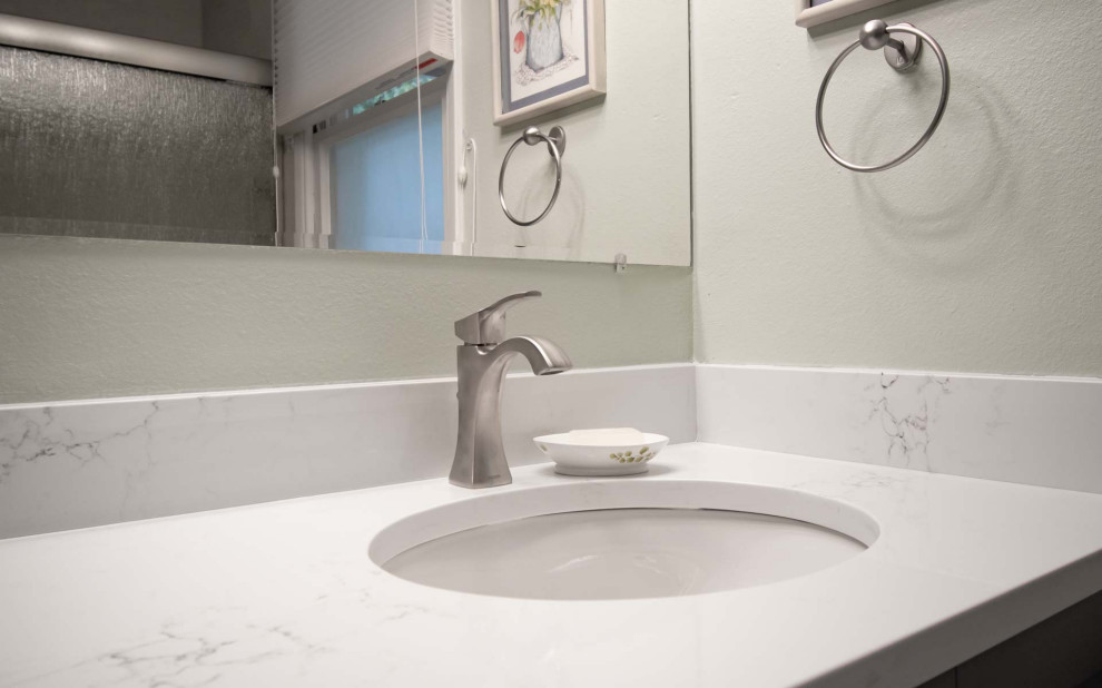 Bild på ett litet vintage vit vitt en-suite badrum, med luckor med infälld panel, grå skåp, ett badkar i en alkov, en dusch/badkar-kombination, en toalettstol med separat cisternkåpa, grå kakel, keramikplattor, blå väggar, klinkergolv i keramik, ett undermonterad handfat, bänkskiva i kvarts, grått golv och dusch med skjutdörr