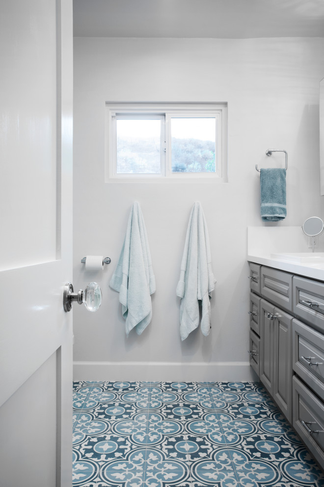 Idee per una stanza da bagno tradizionale con ante con riquadro incassato, ante grigie, top in superficie solida e top bianco