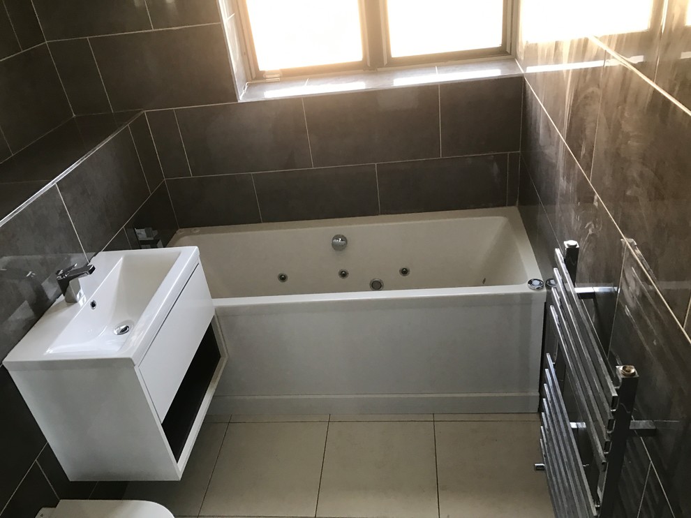 Bild på ett funkis en-suite badrum, med en vägghängd toalettstol, vit kakel, keramikplattor, vita väggar, klinkergolv i porslin och bänkskiva i kvarts