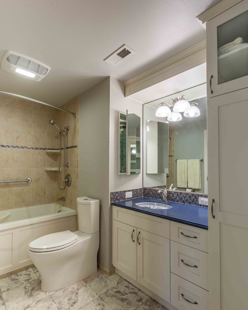 Diseño de cuarto de baño clásico con armarios estilo shaker, puertas de armario blancas, bañera empotrada, combinación de ducha y bañera, paredes grises, lavabo bajoencimera y encimeras azules