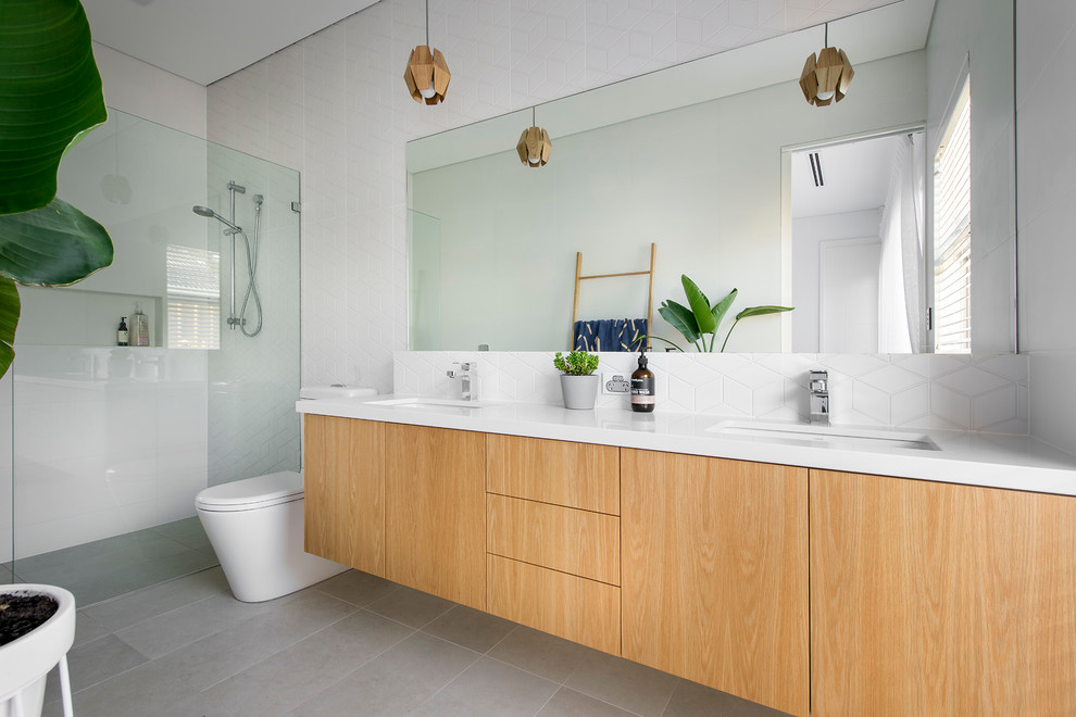 Photo of a small modern bathroom in Perth with white cabinets, engineered stone worktops, a built-in bath, a corner shower, white tiles, porcelain tiles, white walls and porcelain flooring.