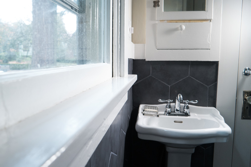 This is an example of a small urban bathroom in Portland with a two-piece toilet, black and white tiles, porcelain tiles, white walls, porcelain flooring and a pedestal sink.