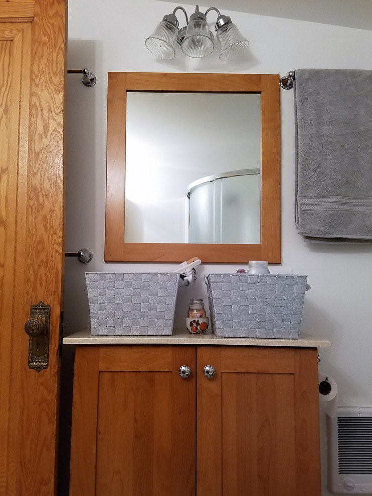 Eklektisk inredning av ett litet badrum med dusch, med släta luckor, skåp i mellenmörkt trä, en hörndusch, vita väggar, vinylgolv, ett integrerad handfat och dusch med skjutdörr
