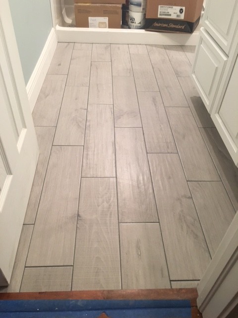 Small elegant 3/4 gray tile and porcelain tile porcelain tile alcove shower photo in Miami with raised-panel cabinets, white cabinets, a one-piece toilet, blue walls, an undermount sink and granite countertops
