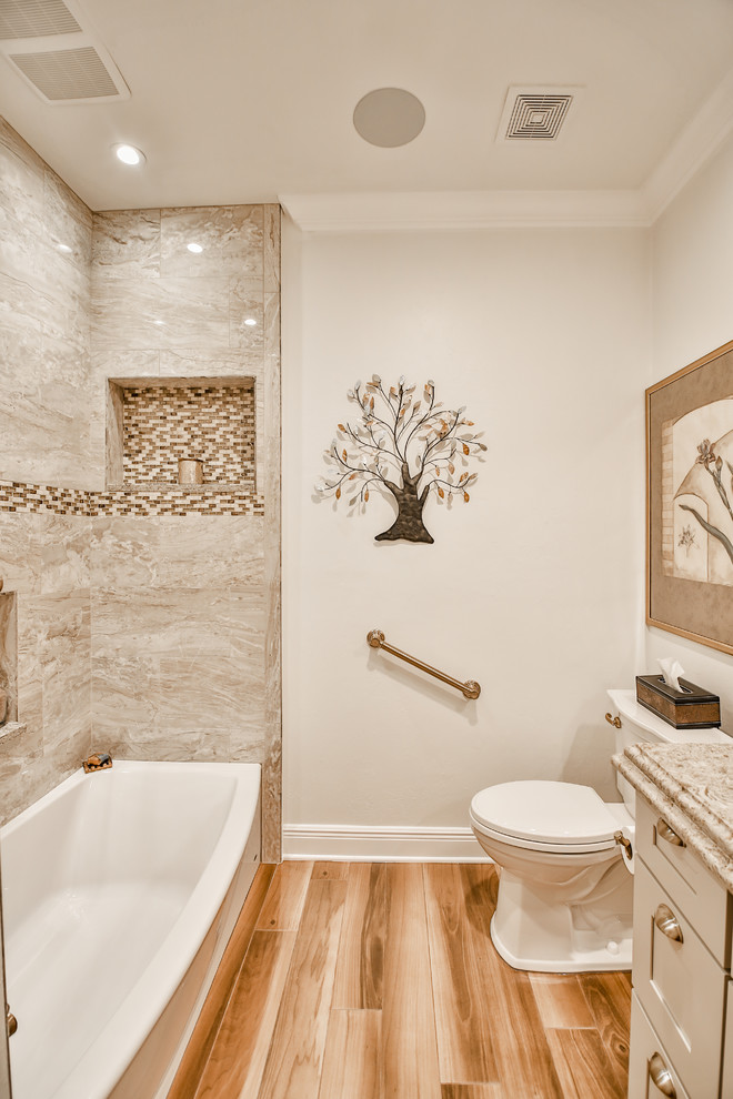 На фото: ванная комната среднего размера в стиле неоклассика (современная классика) с фасадами с утопленной филенкой, серыми фасадами, накладной ванной, душем в нише, раздельным унитазом, керамогранитной плиткой, серыми стенами, полом из керамогранита, настольной раковиной, столешницей из известняка, коричневым полом, шторкой для ванной и коричневой столешницей с