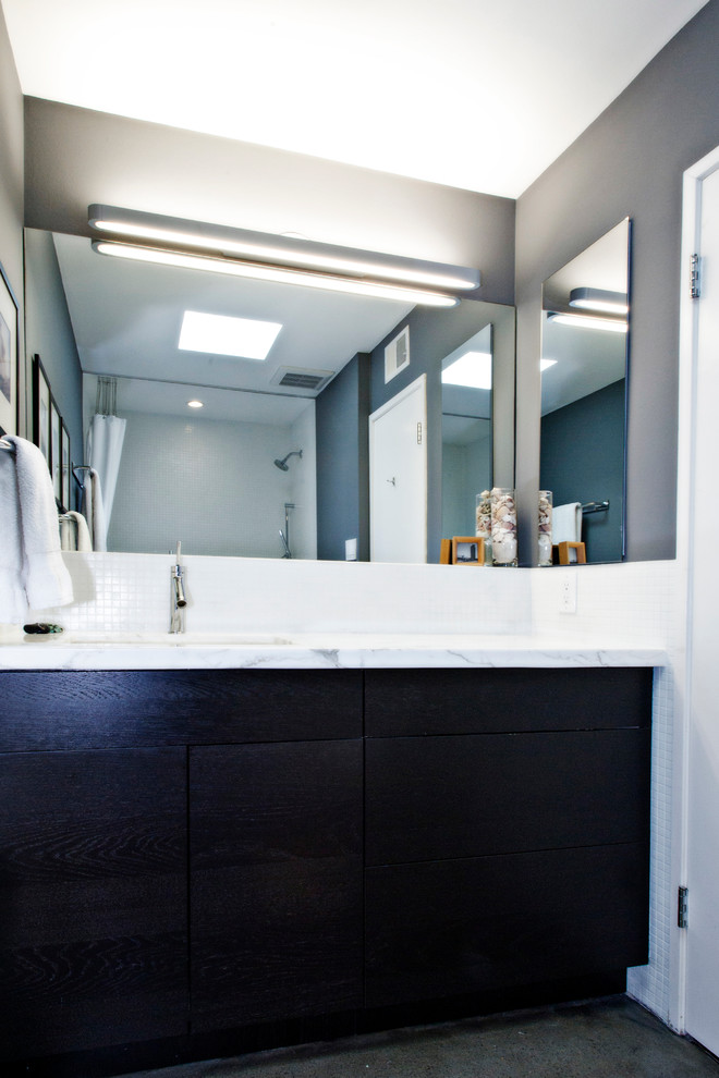 Пример оригинального дизайна: ванная комната в стиле ретро с врезной раковиной, плоскими фасадами, темными деревянными фасадами, мраморной столешницей, ванной в нише, душем над ванной, раздельным унитазом и белой плиткой