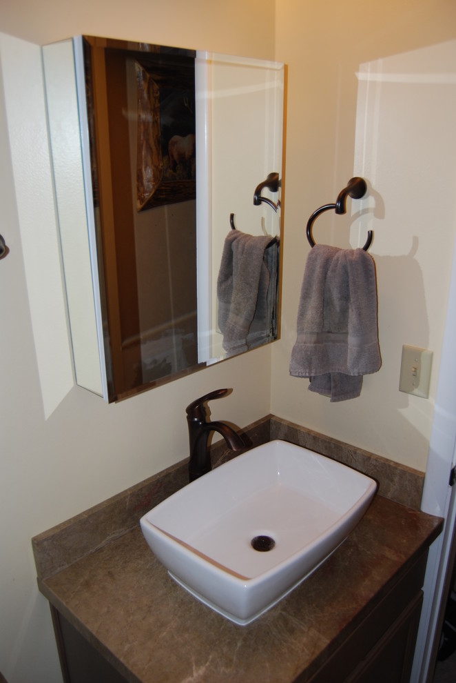 Cette photo montre une petite salle de bain chic en bois clair avec un placard avec porte à panneau encastré, un plan de toilette en surface solide, WC séparés, un carrelage marron, des carreaux de porcelaine, un mur beige, un sol en carrelage de porcelaine, une vasque, un sol marron et une cabine de douche à porte battante.