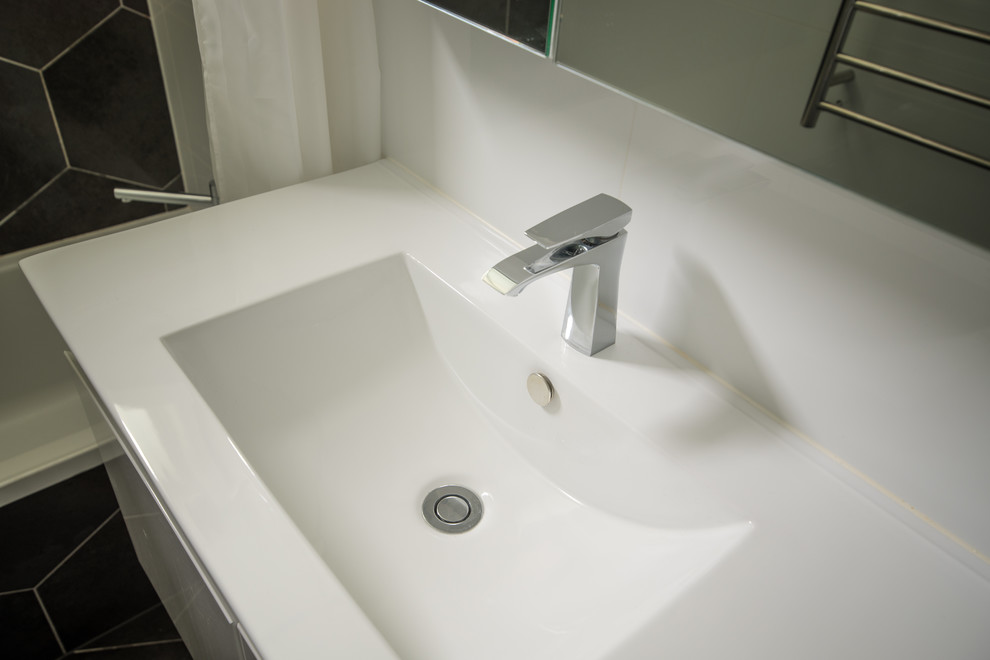 Esempio di una piccola stanza da bagno moderna con ante lisce, ante bianche, pareti bianche e lavabo integrato