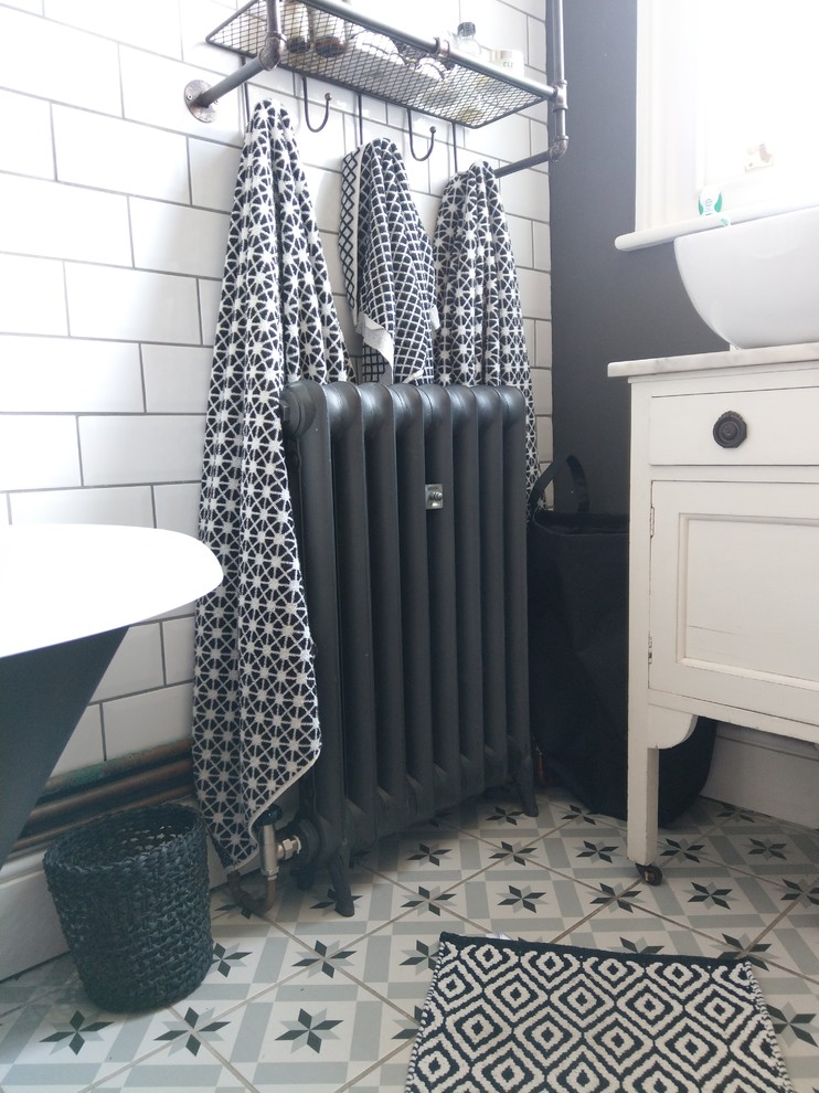 Small urban family bathroom in London with freestanding cabinets, white cabinets, a claw-foot bath, a shower/bath combination, white tiles, metro tiles, grey walls, porcelain flooring, marble worktops, grey floors and a shower curtain.