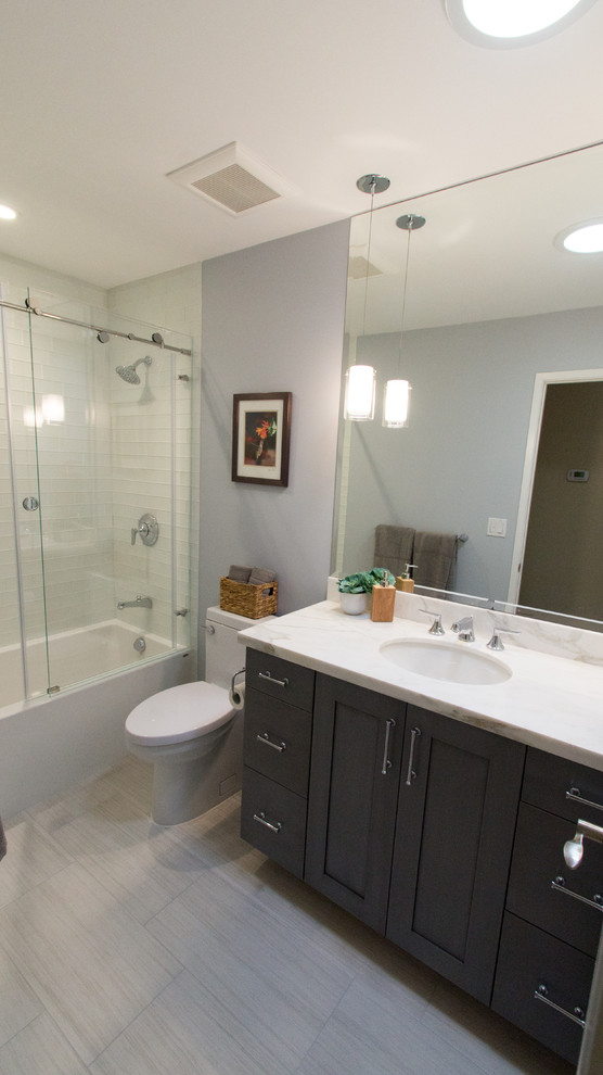 Inredning av ett modernt litet badrum, med skåp i shakerstil, grå skåp, glaskakel, blå väggar, klinkergolv i porslin, ett undermonterad handfat och marmorbänkskiva