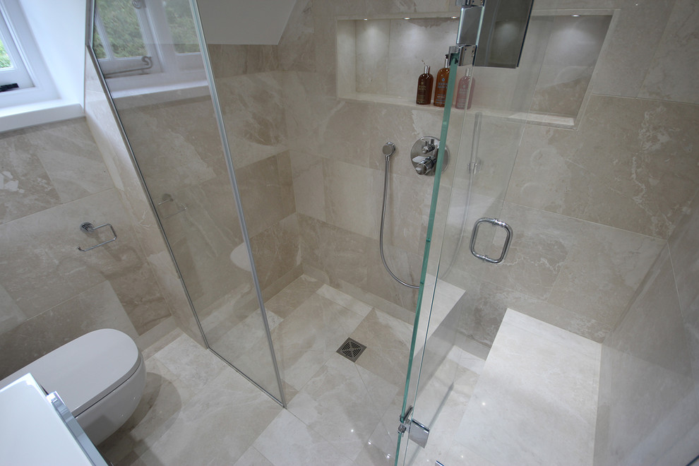 Foto di una piccola stanza da bagno con doccia contemporanea con lavabo sospeso, ante in legno bruno, top in superficie solida, doccia aperta, WC sospeso, piastrelle beige, piastrelle in pietra, pareti beige e pavimento in marmo