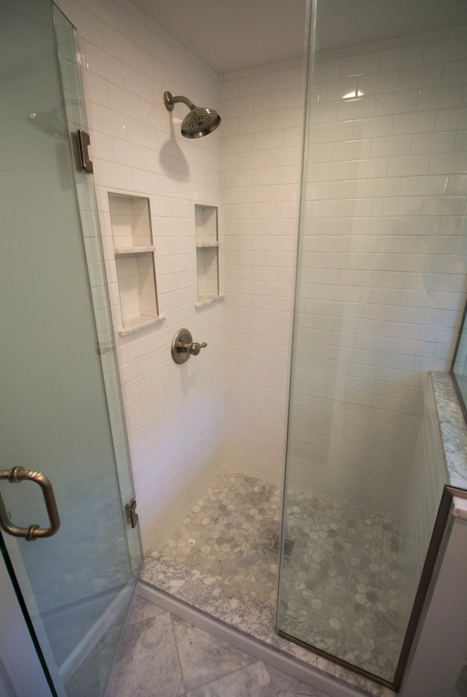 Corner shower - small transitional master white tile and ceramic tile marble floor and gray floor corner shower idea in Newark with shaker cabinets, white cabinets, a two-piece toilet, gray walls, an undermount sink, marble countertops and a hinged shower door