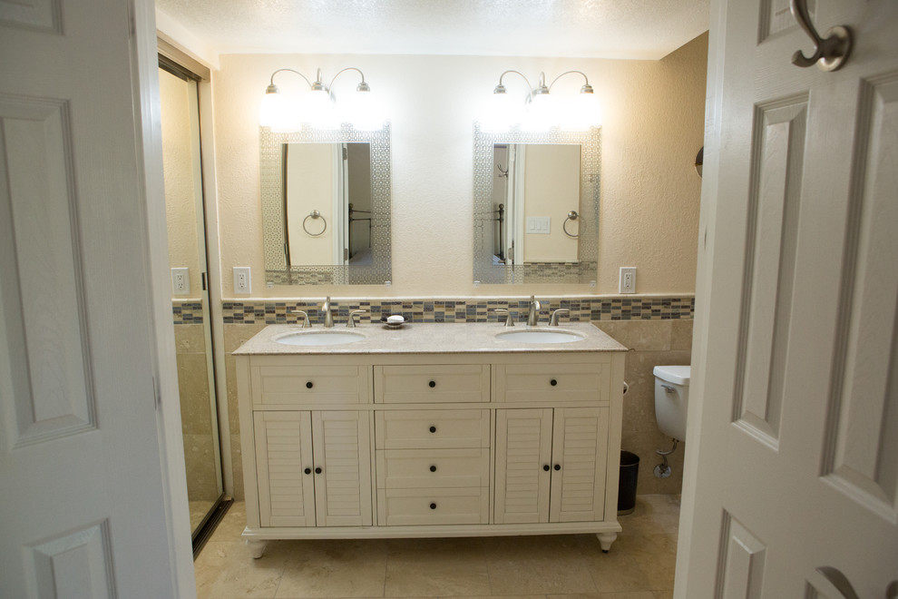 Photo of a medium sized traditional ensuite bathroom in Phoenix with louvered cabinets, white cabinets, a built-in bath, a shower/bath combination, a two-piece toilet, blue tiles, travertine tiles, beige walls, travertine flooring, a submerged sink, engineered stone worktops, beige floors and a shower curtain.