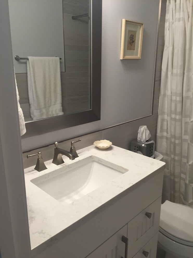 Photo of a small classic ensuite bathroom in Baltimore with shaker cabinets, white cabinets, an alcove shower, a two-piece toilet, grey tiles, porcelain tiles, grey walls, ceramic flooring, a submerged sink, engineered stone worktops, white floors and a shower curtain.