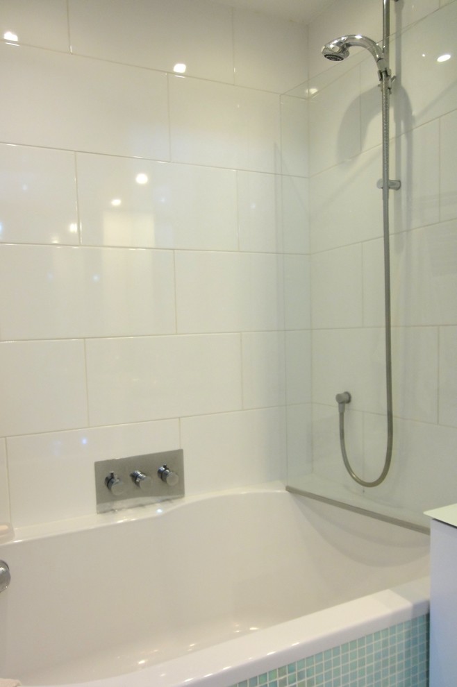 Exemple d'une petite salle de bain moderne avec une baignoire en alcôve, un combiné douche/baignoire, un carrelage blanc, des carreaux de céramique, un mur blanc et un sol en carrelage de céramique.